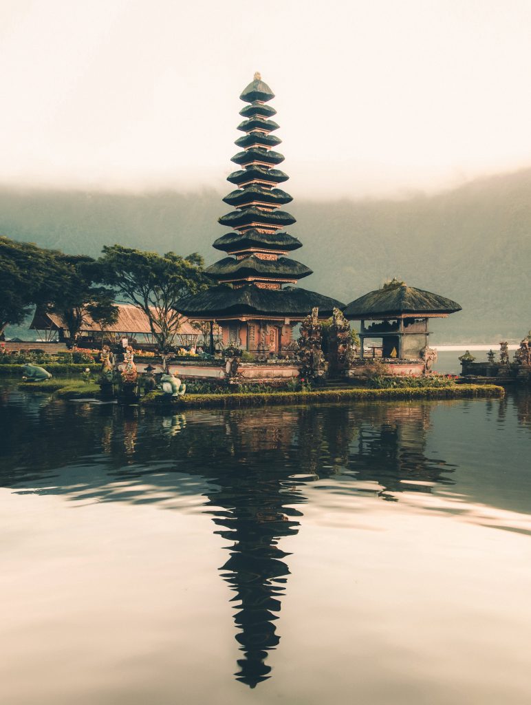 Serene Balinese temple nestled amidst lush tropical greenery, a tranquil oasis amidst nature's embrace.
